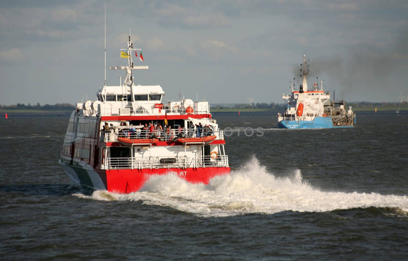 This motor catamaran sails almost daily to Heligoland. The blue ship in the background is a dredging ship.