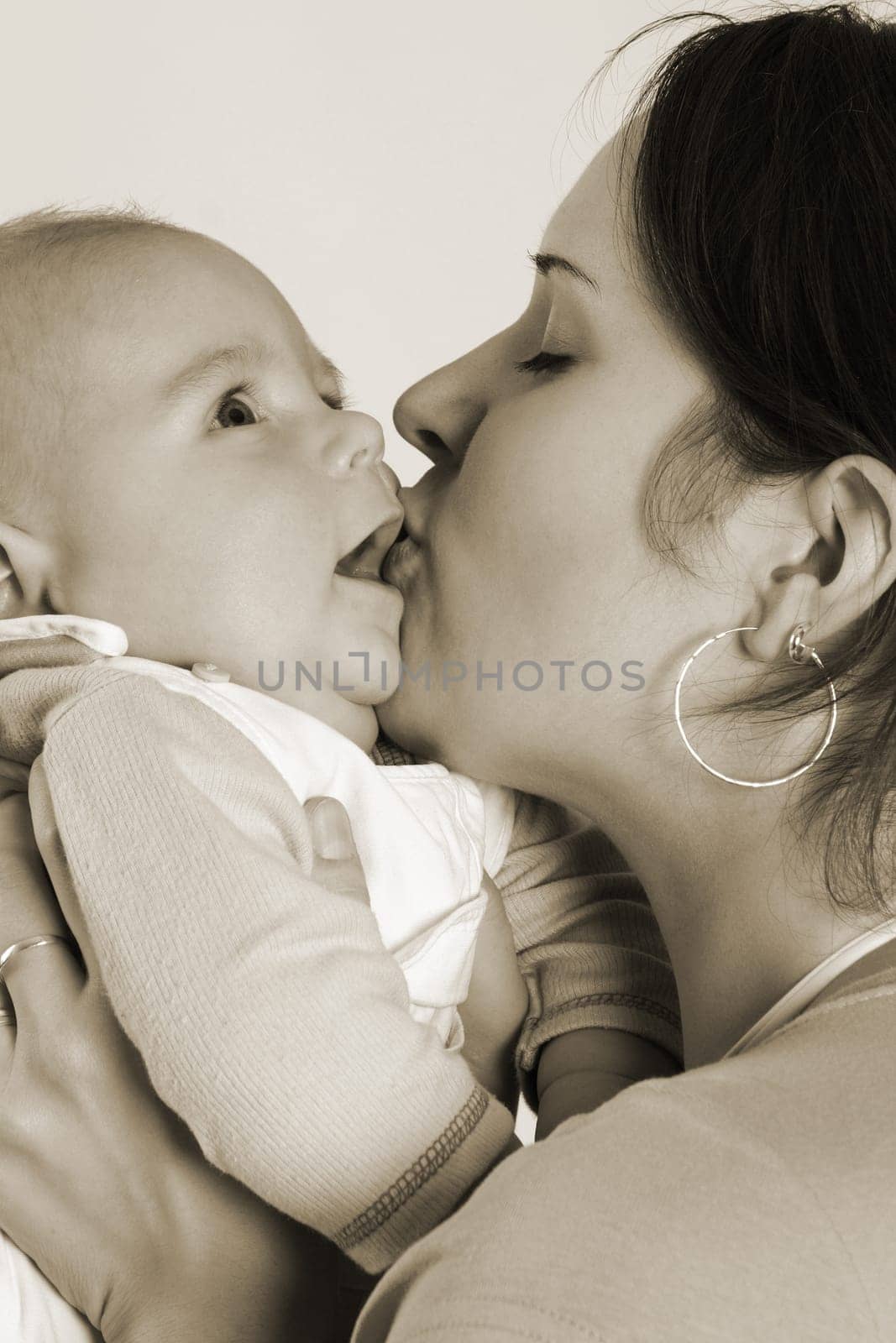 Mom kisses her child,which she holds in her arms