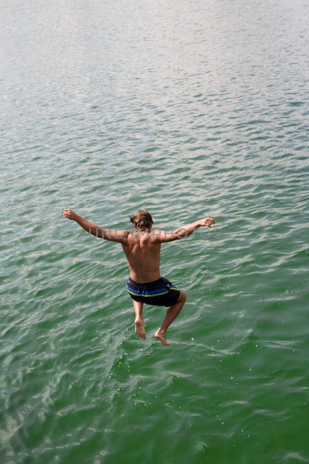 A young man jumps into the water