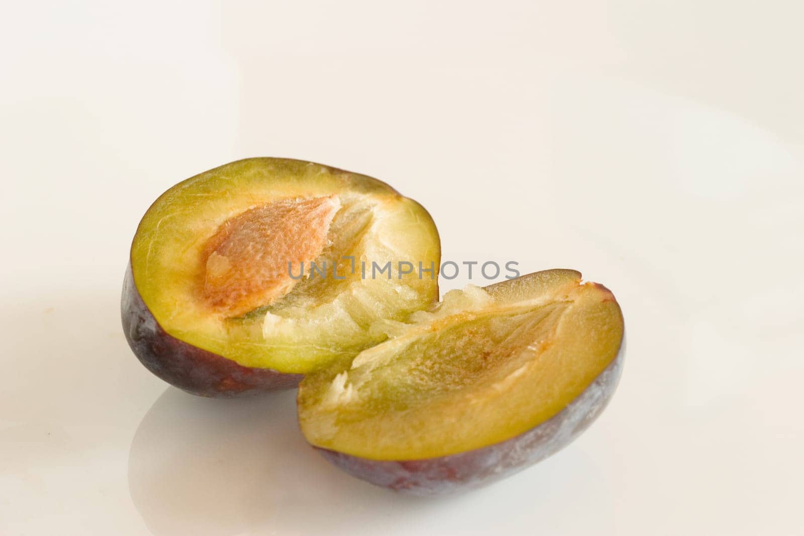 Plums,halved on a white background