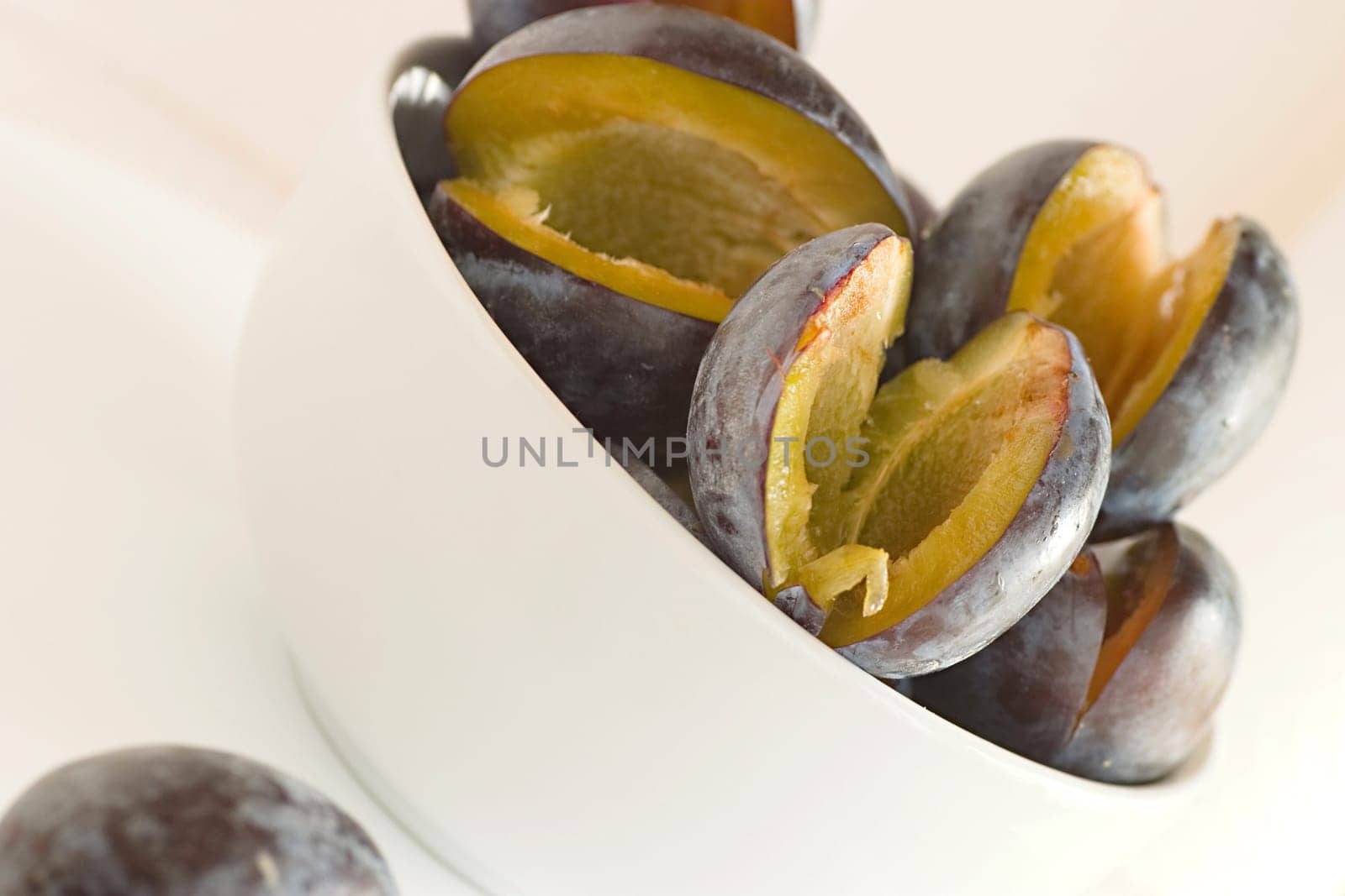 Plums,halved on a white background