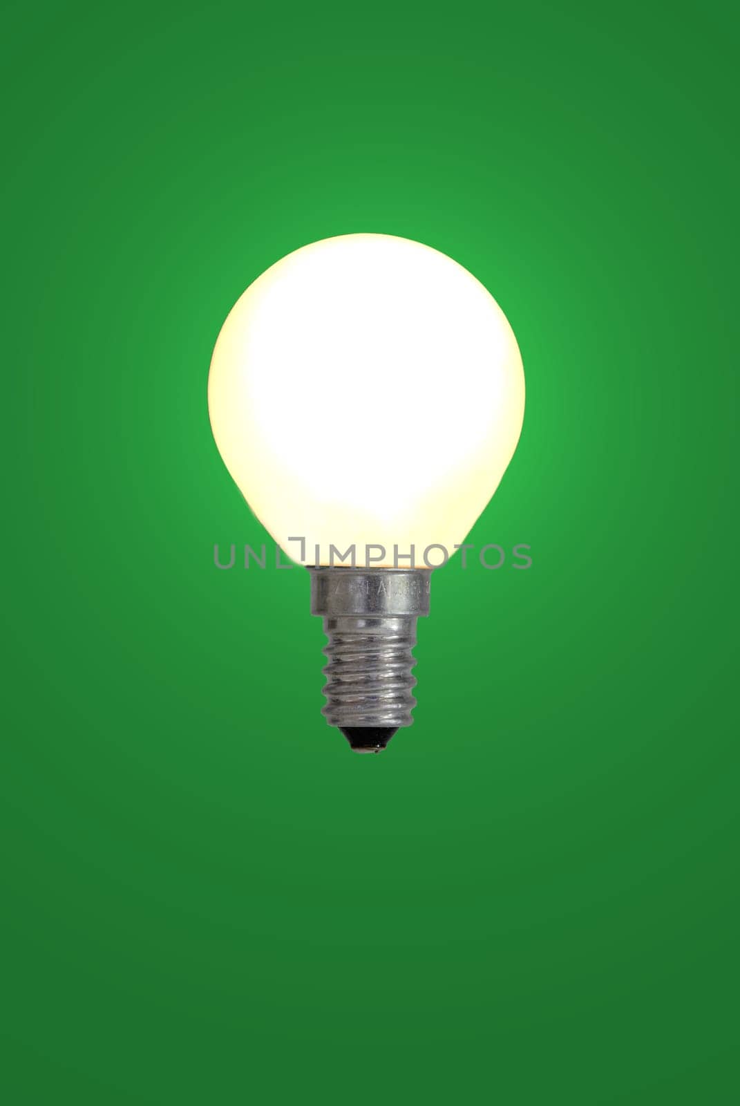 Light bulb against a green background