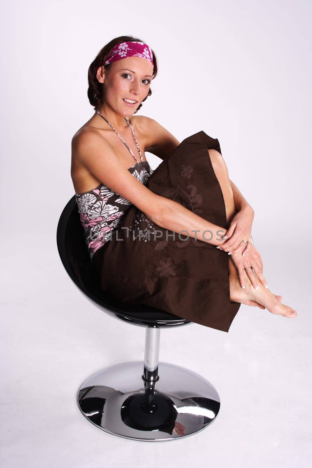 A woman sits on a swivel stool in the style of the 70s