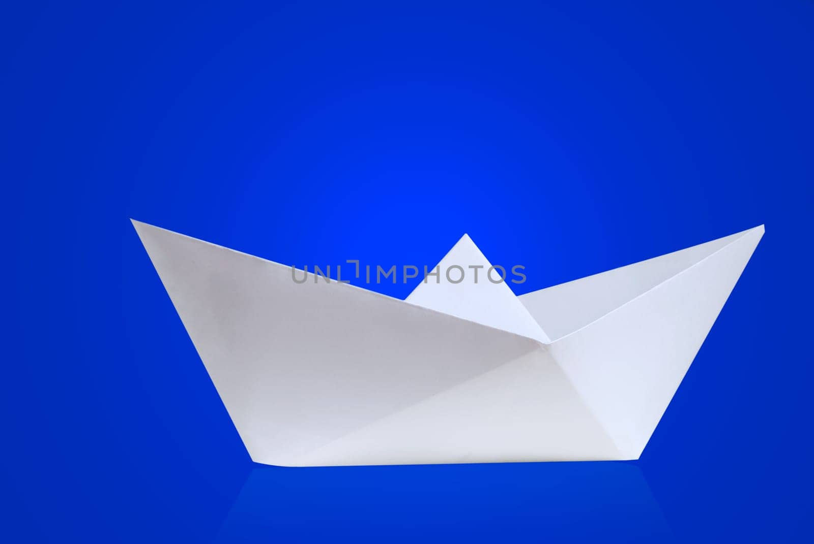 Paper ship against blue background