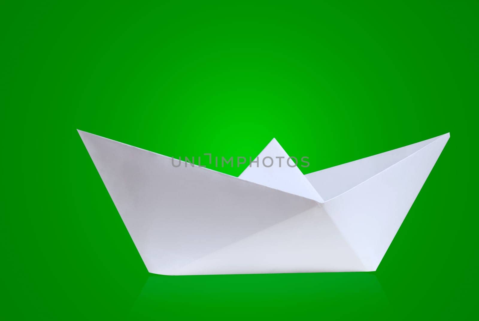 Paper boat against a green background