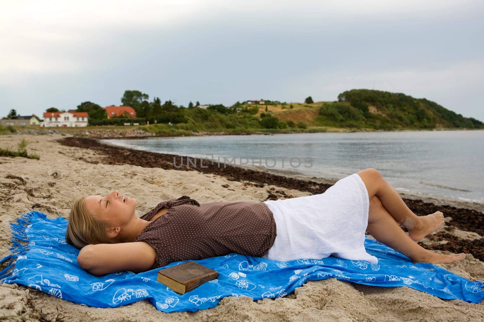 A young woman lies relaxed on the beach