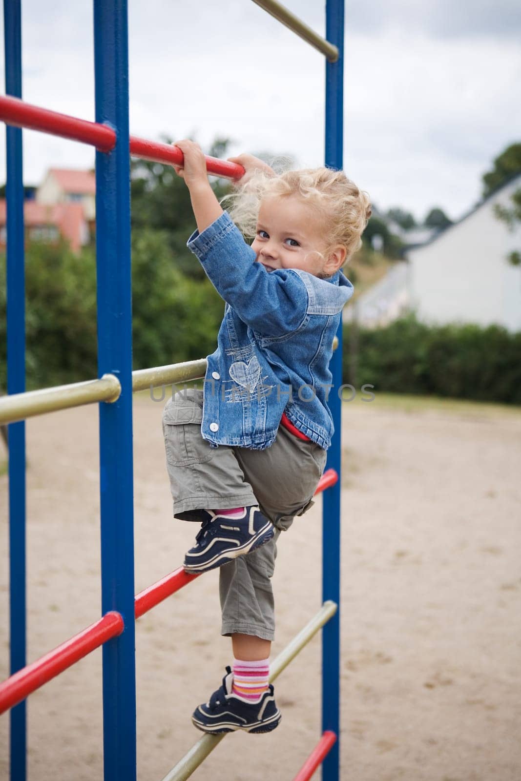 A little girl on a jungle gym