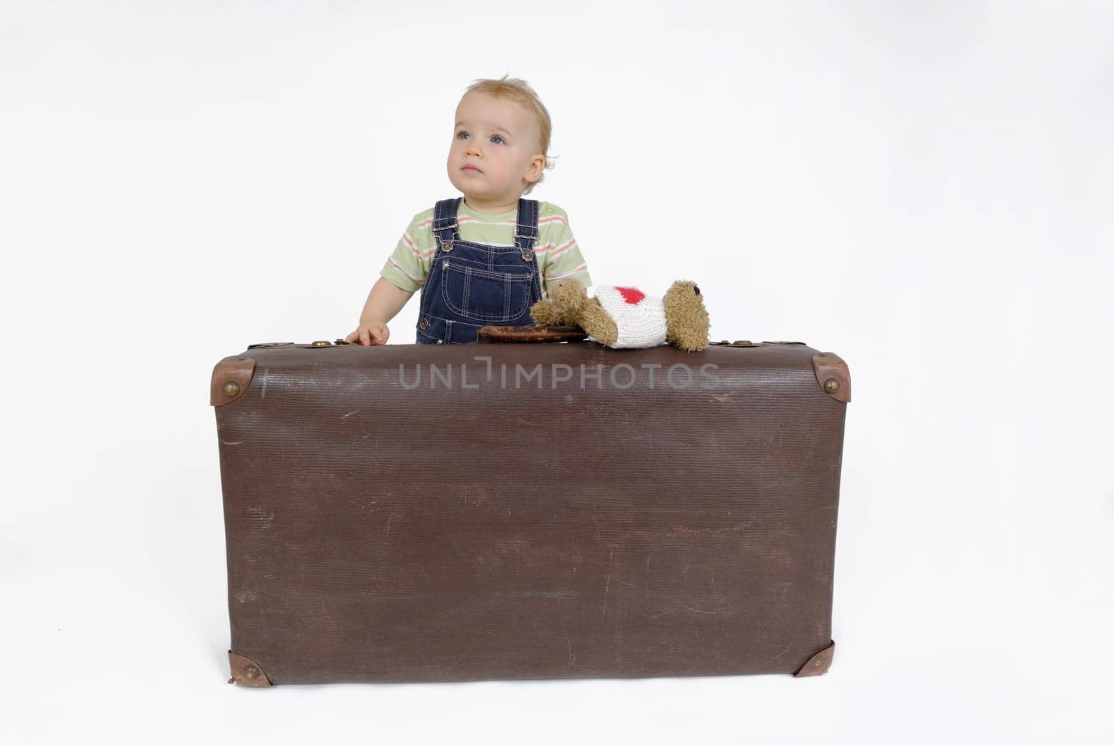 Toddler with suitcase and teddy bear. Studio recording