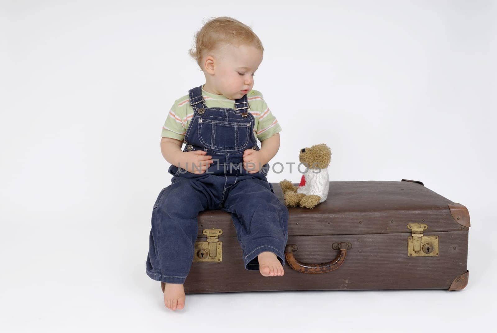 Toddler on suitcase. Studio recording