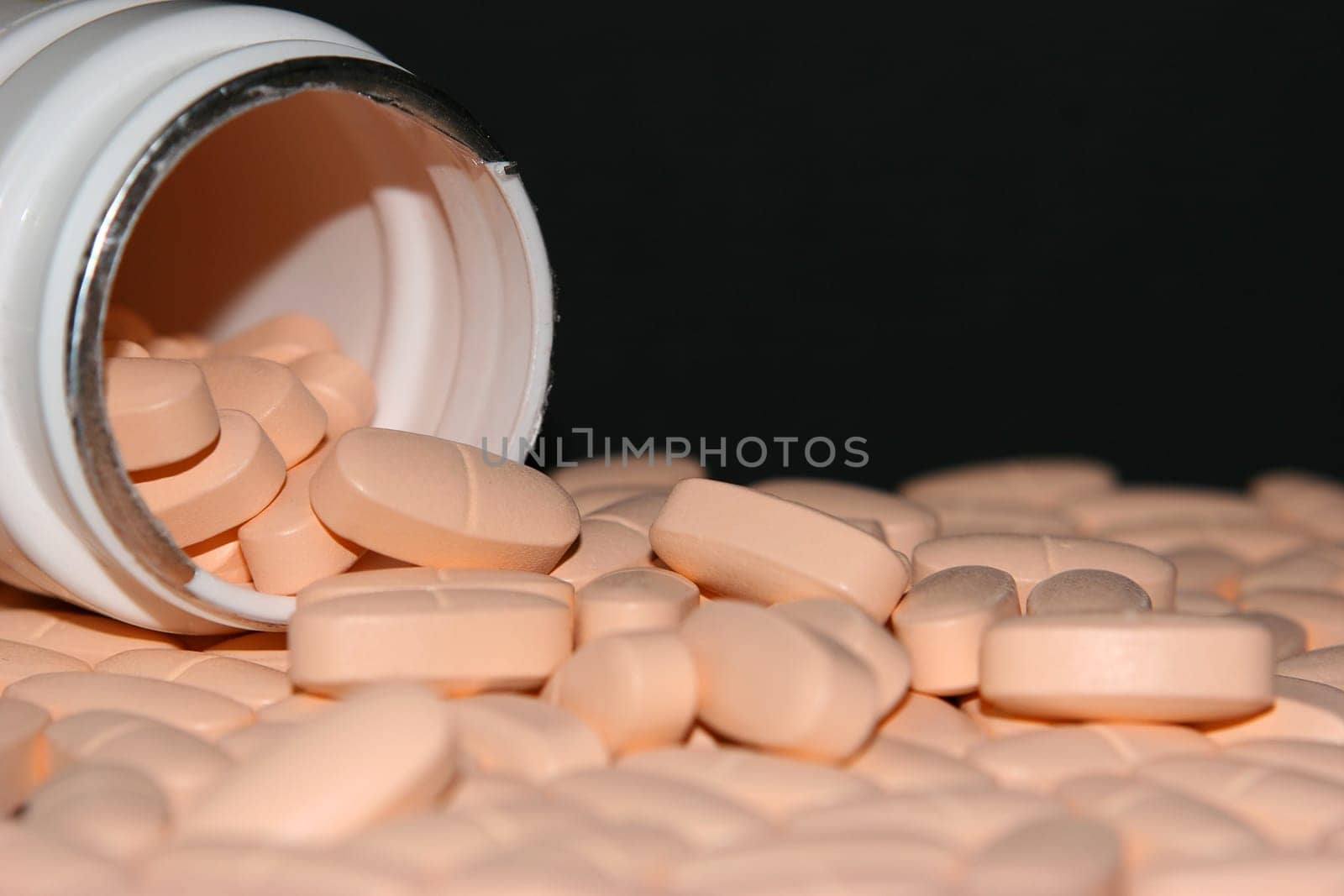 Can and tablets on black background