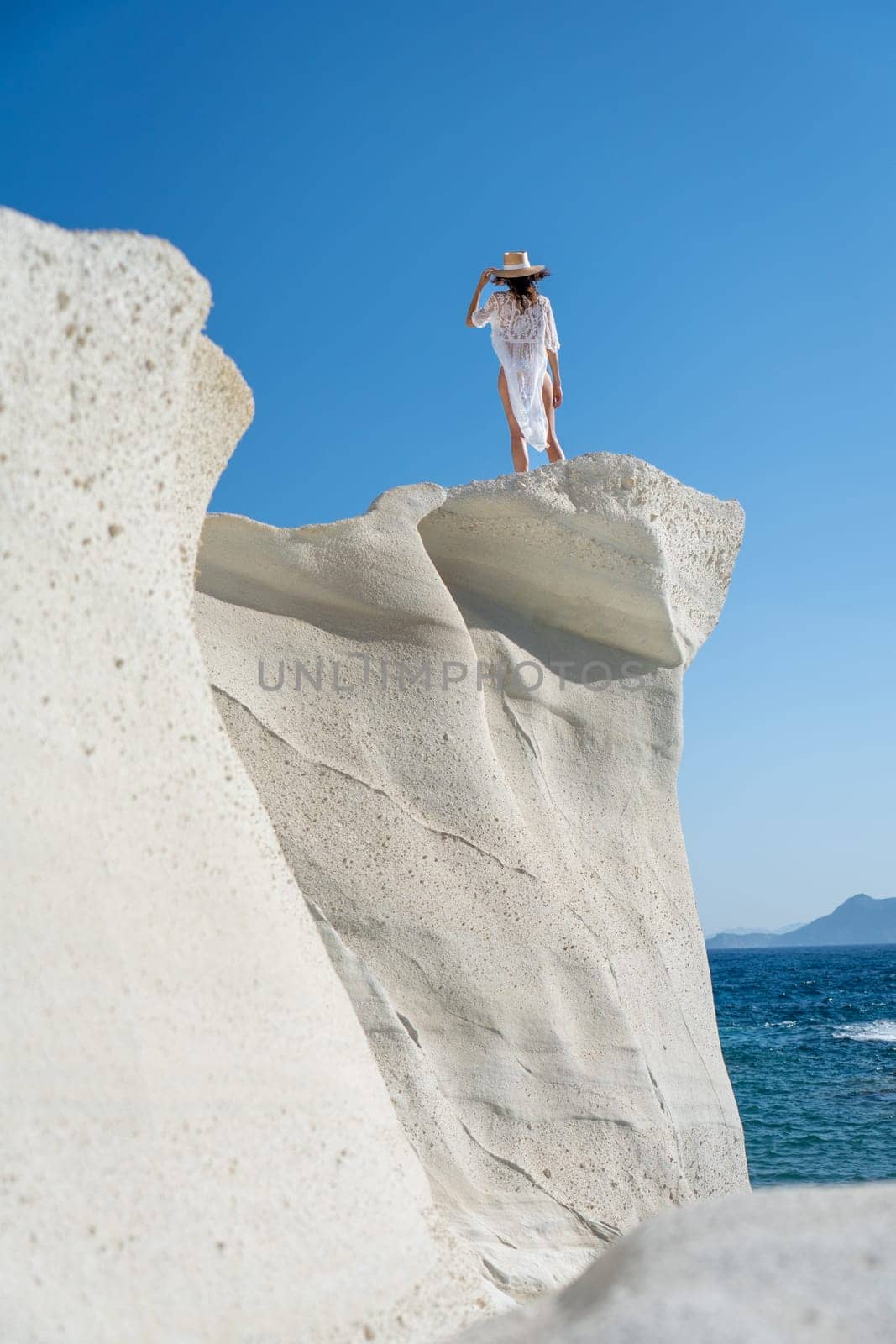 Model on top of a cliff in Sarakiniko, Milos Island by LopezPastor