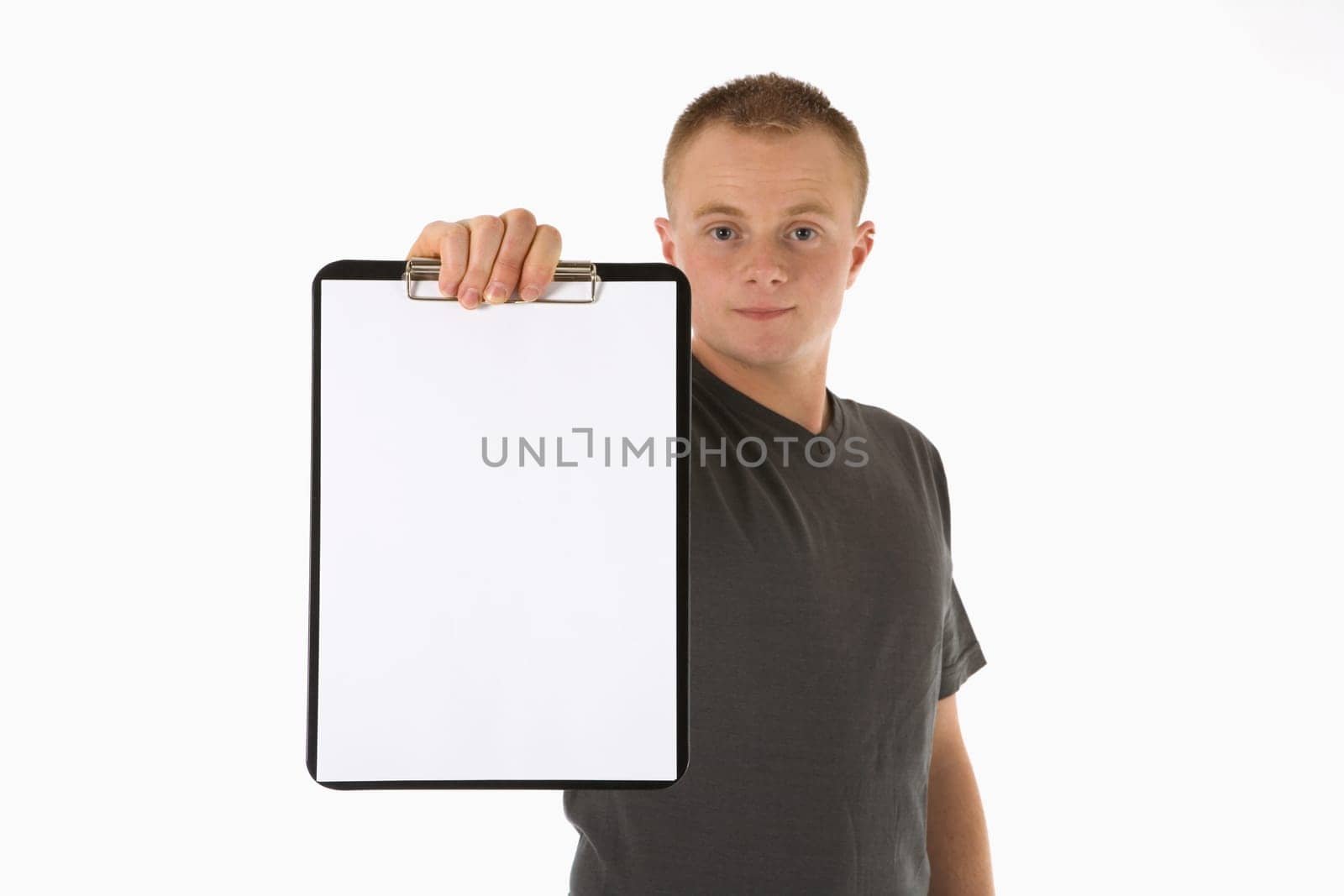 A young man holds a paper clipboard
