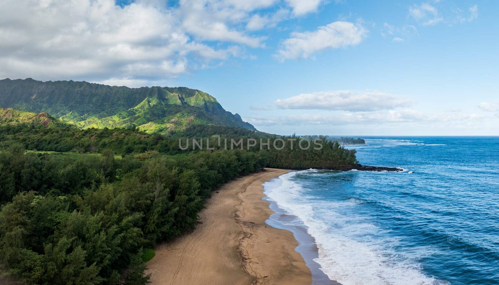 Aerial panoramic image off the coast over Lumaha'i beach on Hawaiian island of Kauai with Na Pali mountains behind. Taken at dawn