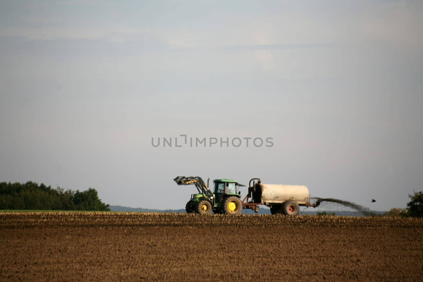 Tractor on a field spreading manure