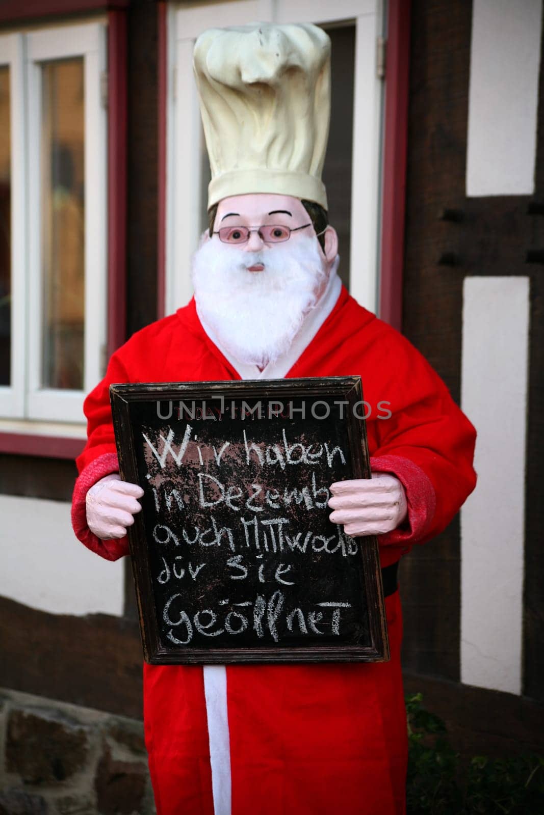 Chef figure dressed as Santa Claus in front of a restaurant