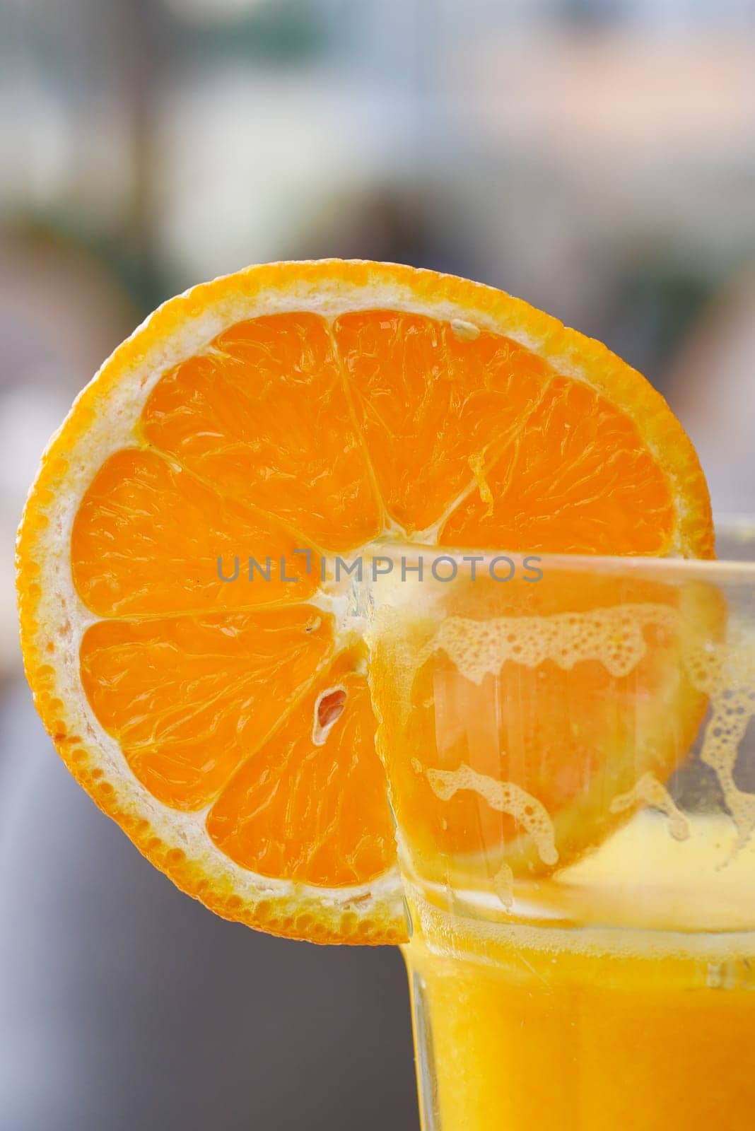 Orange cocktail in a glass on table .