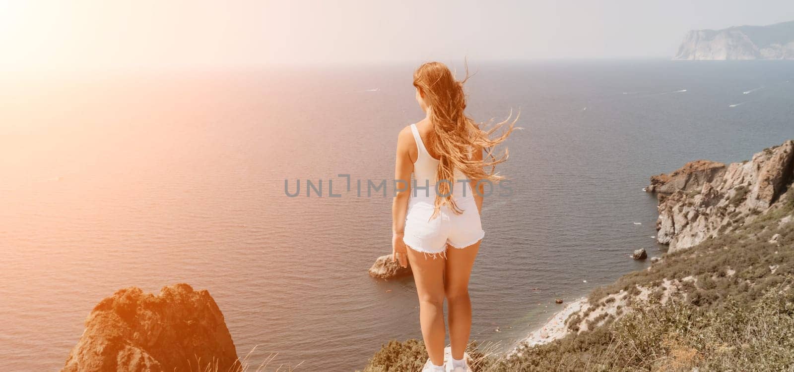 Woman summer travel sea. Happy tourist enjoy taking picture outdoors for memories. Woman traveler posing over sea bay surrounded by volcanic mountains, sharing travel adventure journey by panophotograph