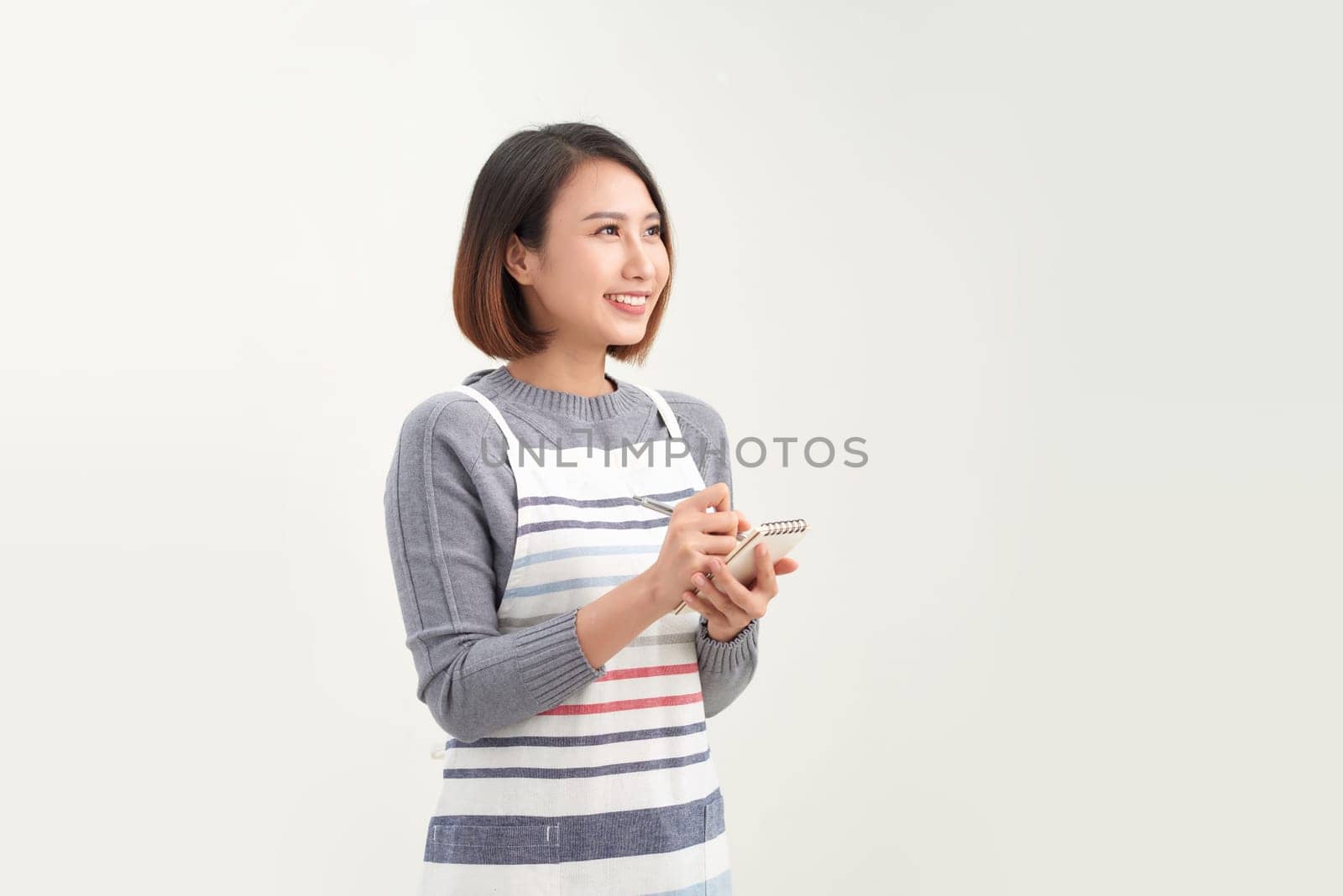 Young beautiful asian woman waitress smiling confident taking notes on white background