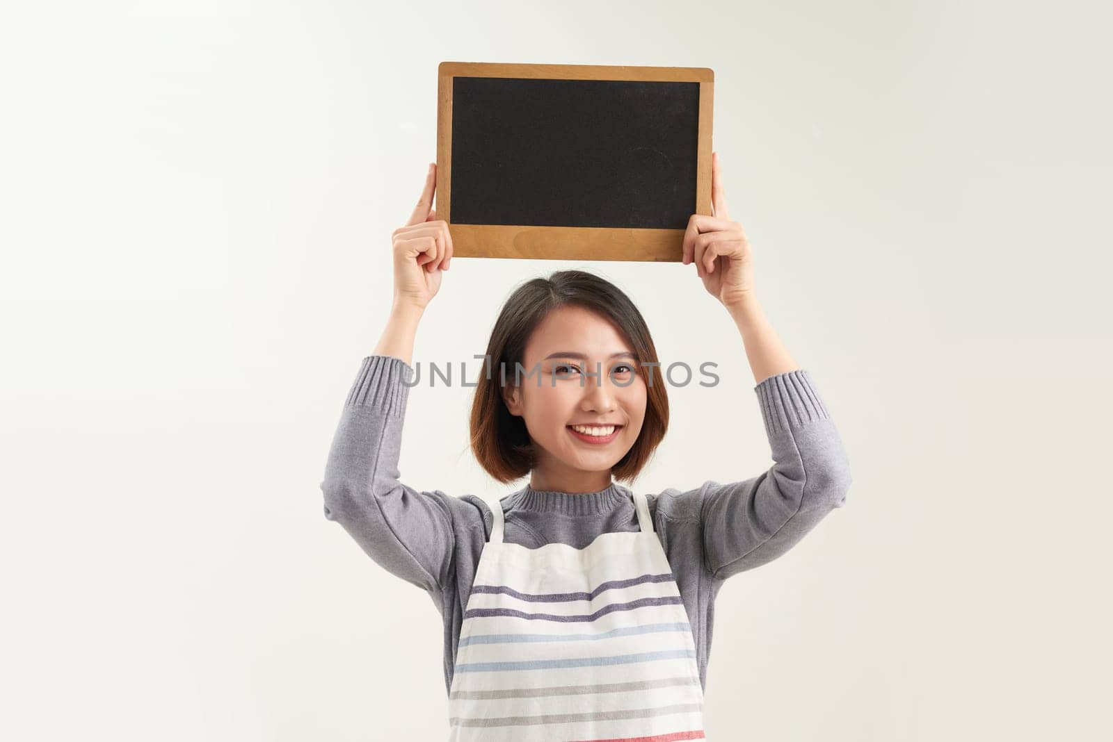 Happy waitress holding blank chalkboard sign. by makidotvn