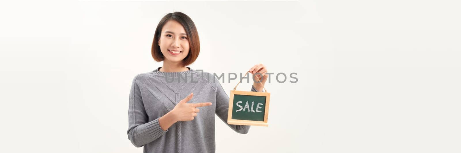 Beautiful asian woman in barista apron holding SALE word blackboard sign on white background