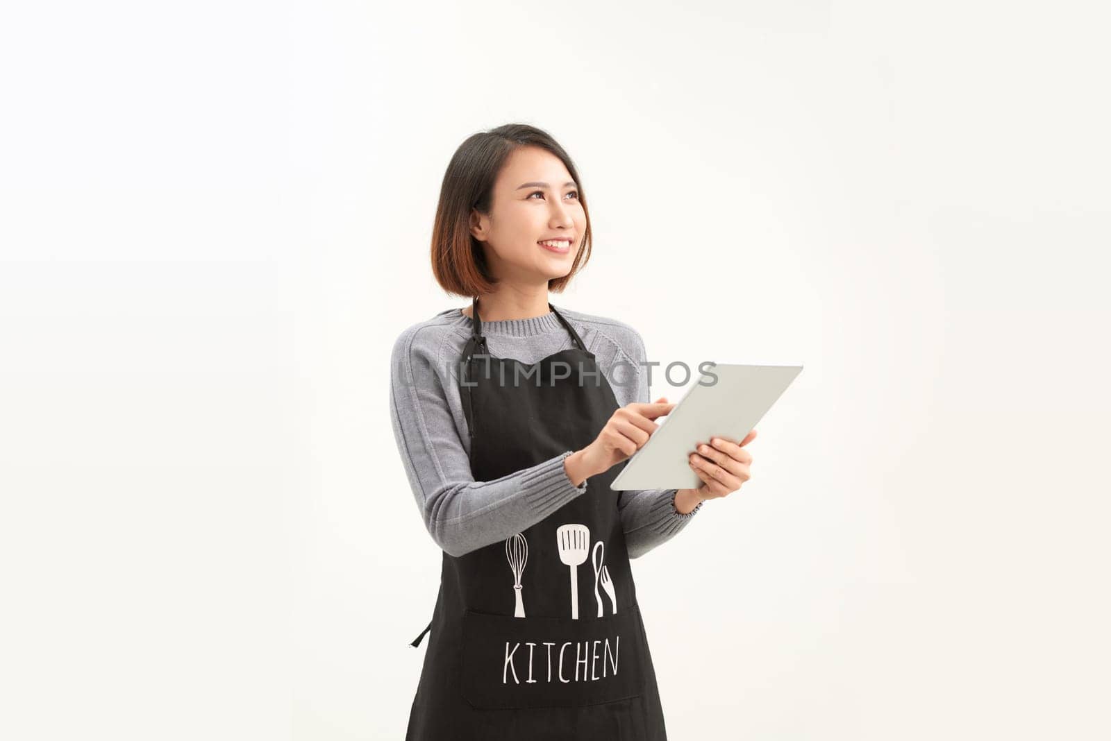 Portrait of young cafe asian waitress using digital tablet on white background