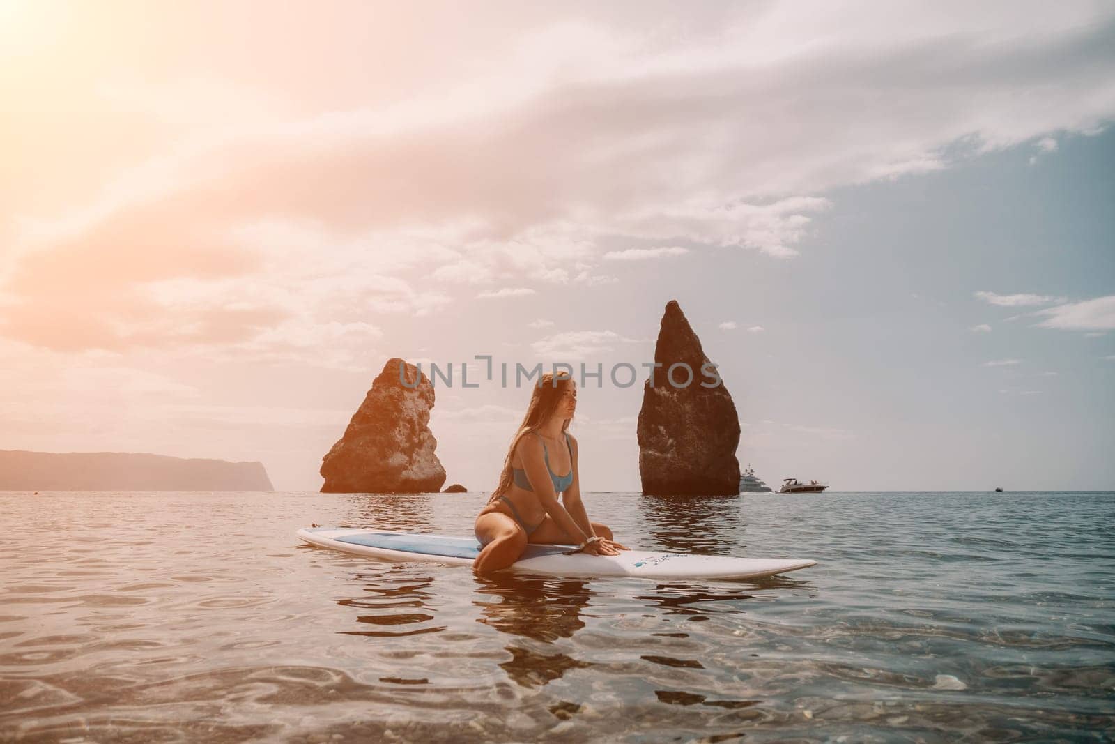 Woman sea sup. Close up portrait of happy young caucasian woman with long hair looking at camera and smiling. Cute woman portrait in bikini posing on sup board in the sea by panophotograph