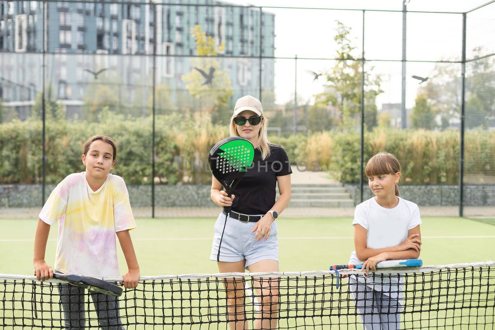 mother and daughters playing padel outdoor. High quality photo