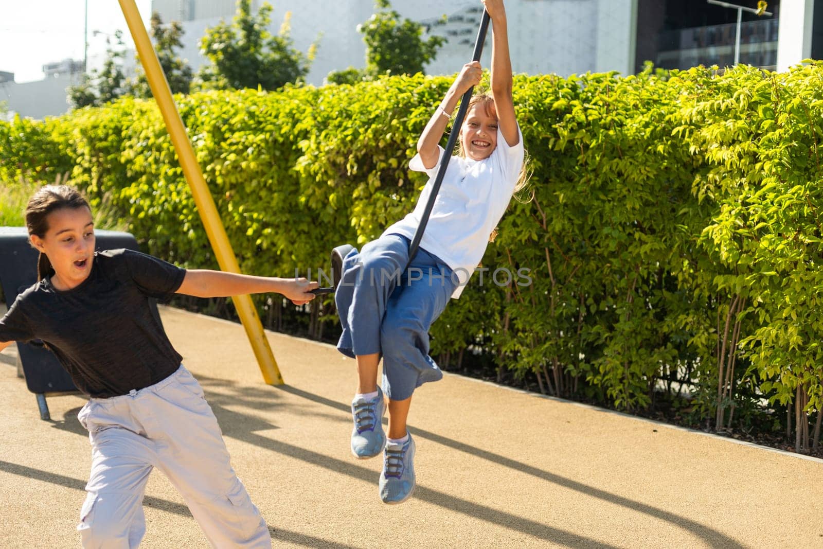 Caucasian little girls enjoying at outdoor children playground. Small girls playing at the park. High quality photo