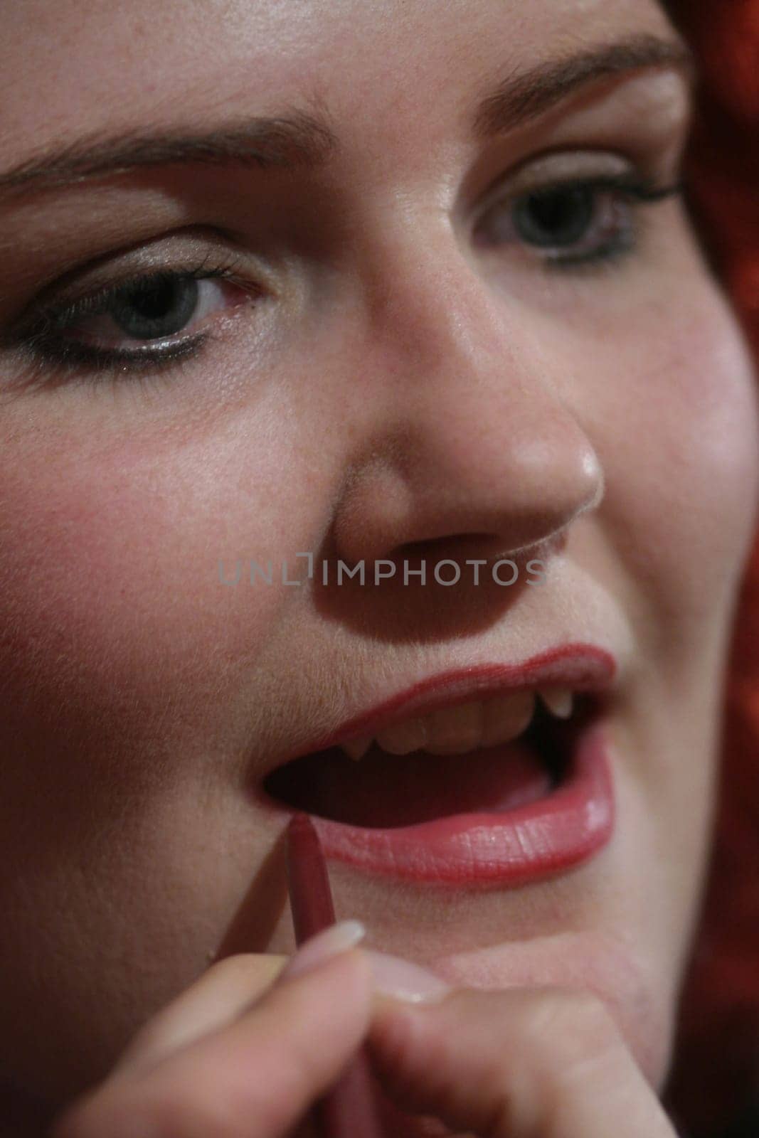 red-haired woman doing makeup