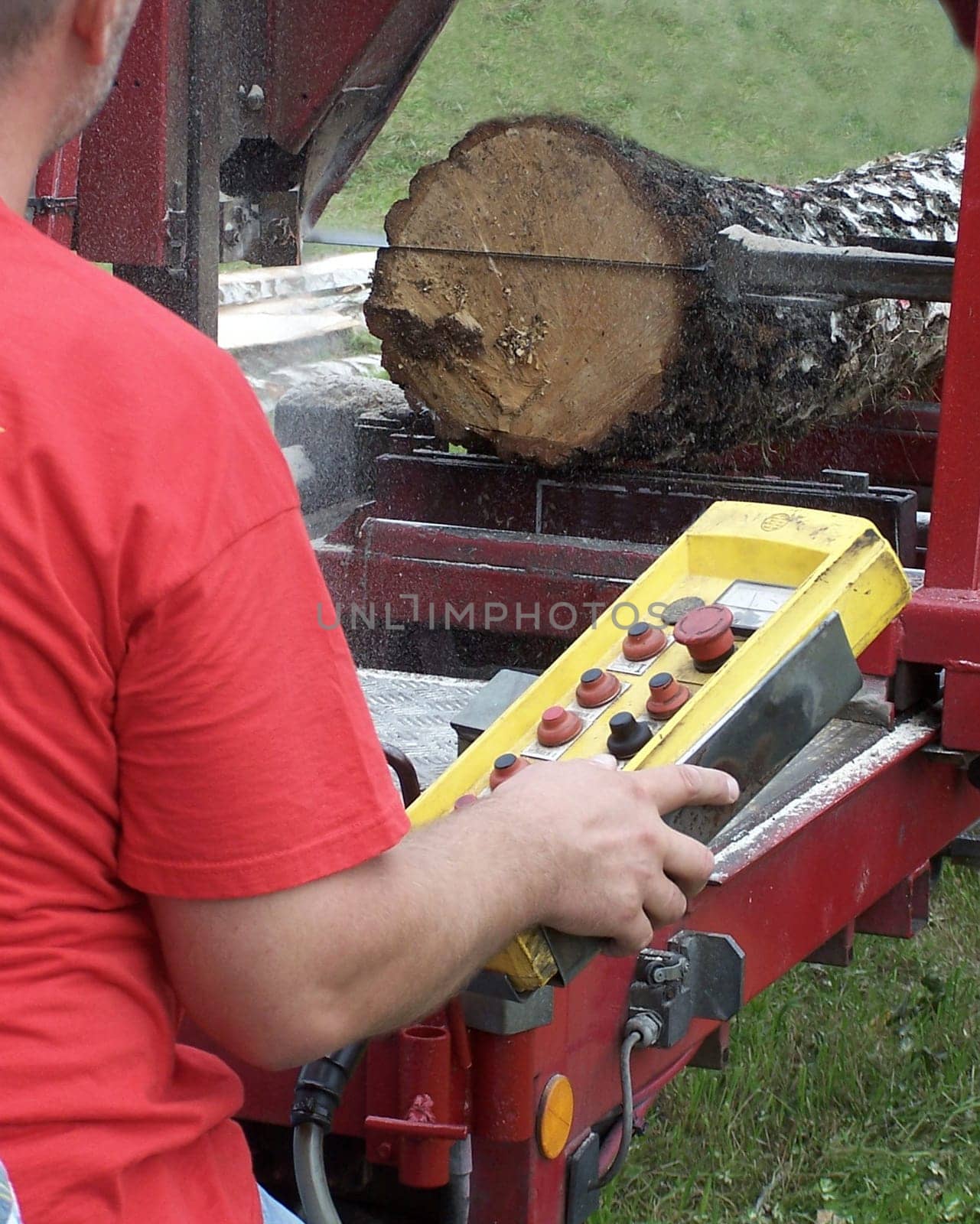Worker operates mobile sawmill