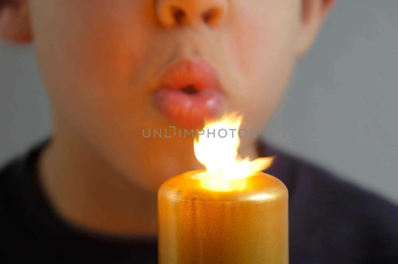 Boy blows out a candle