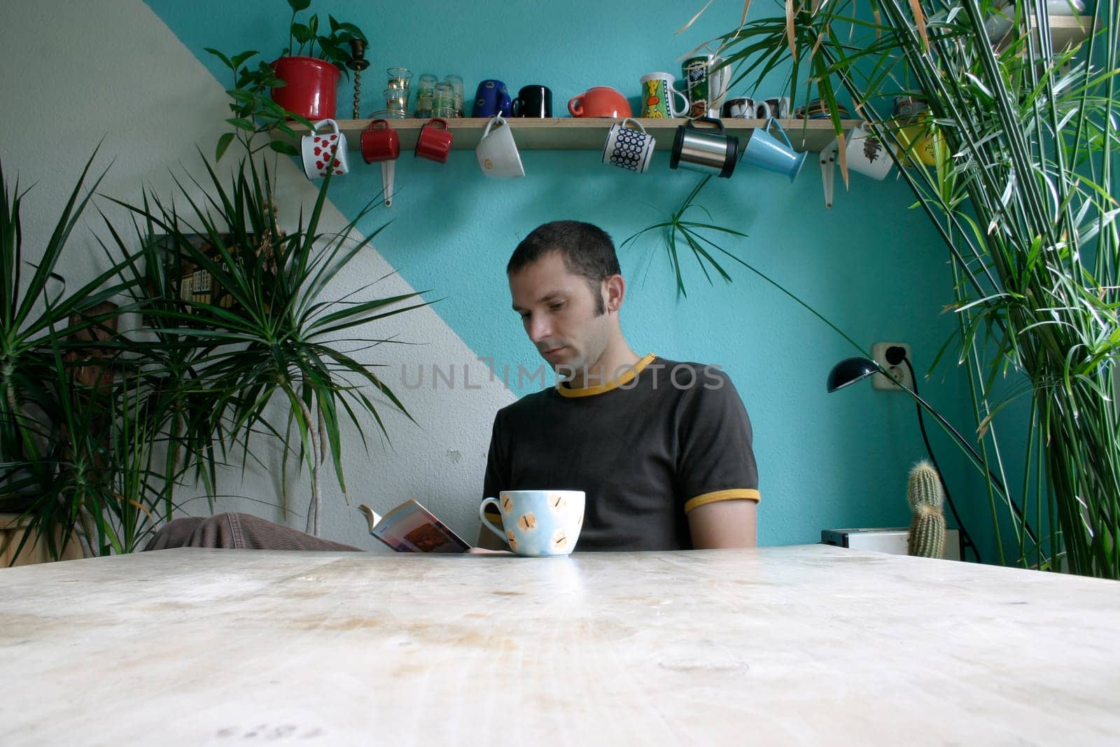 Young man sitting at the table and reading