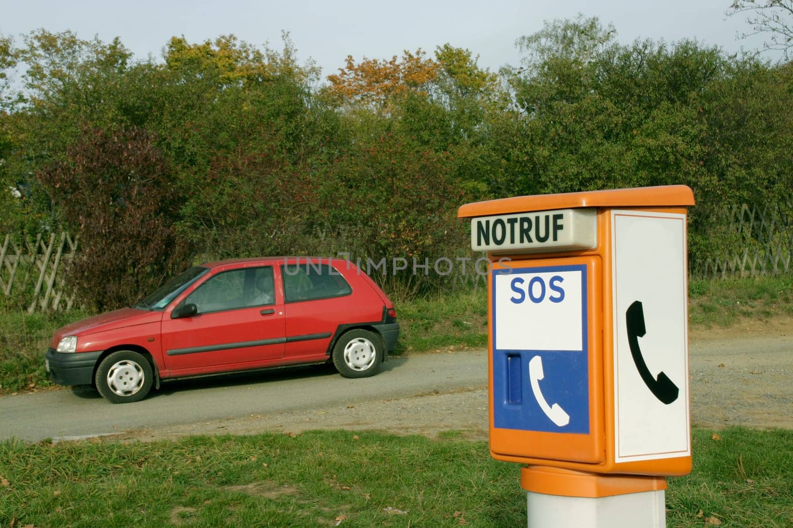 Emergency telephone,red car,road