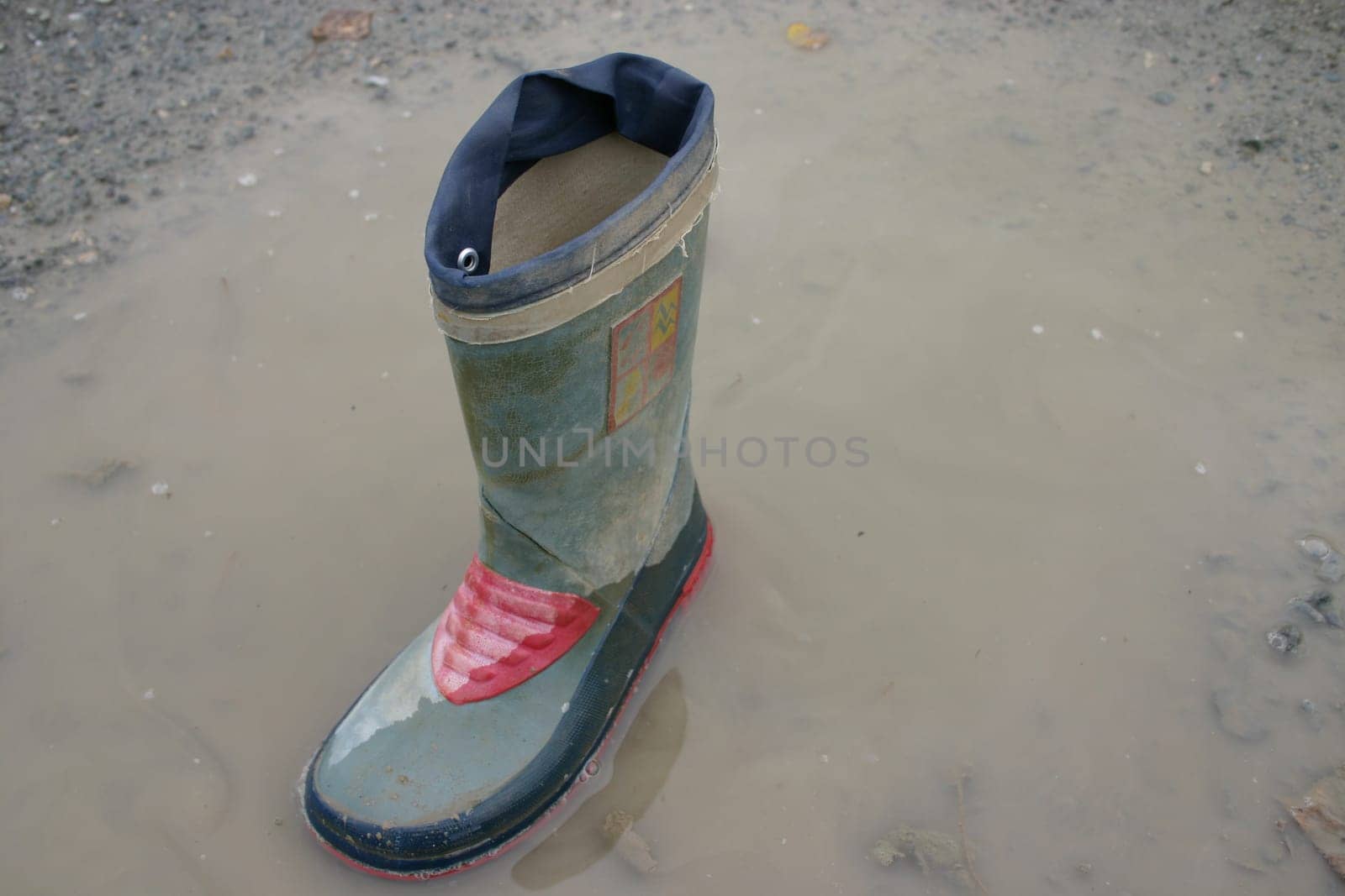 Rubber boots in puddle
