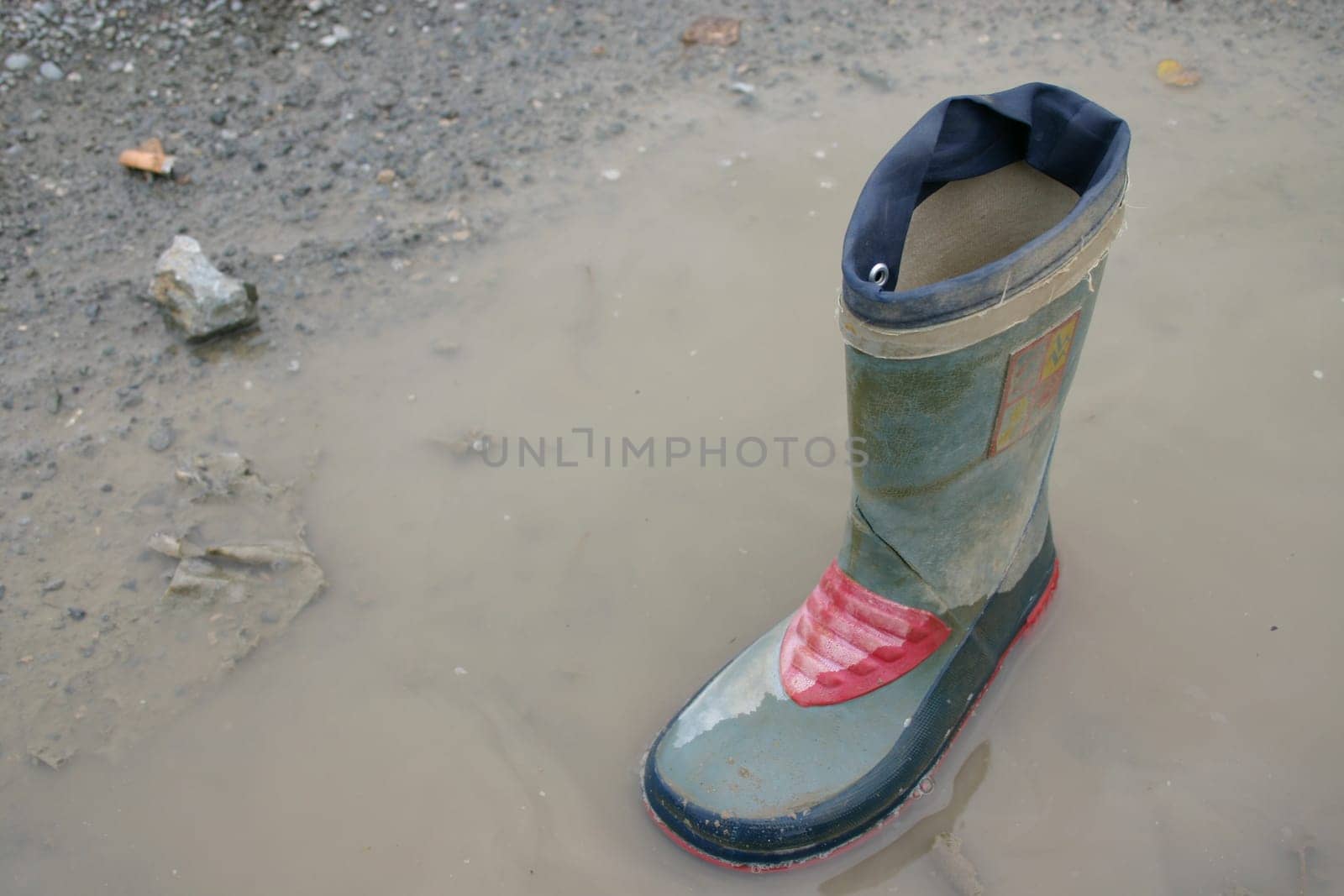 Rubber boots in puddle