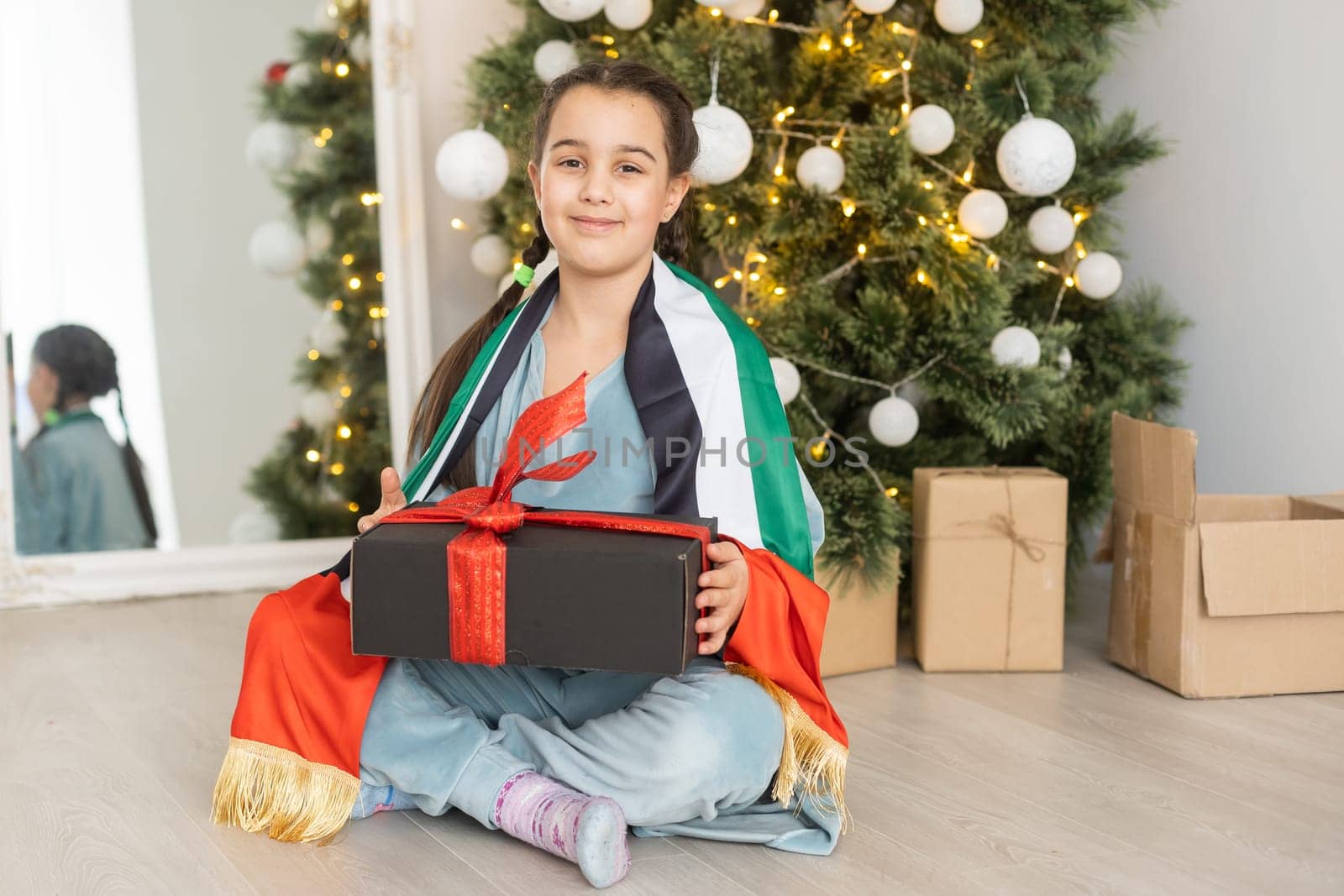 little girl with flag of united arab emirates at christmas.