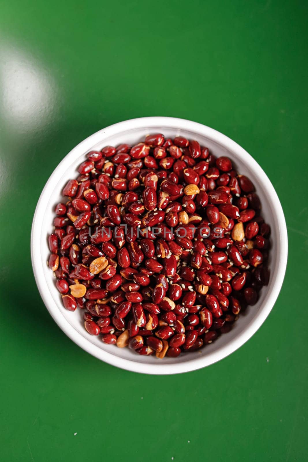 red roasted peanuts in a white bowl. Garnish. View from above. Chinese cuisine, hotpot ingredient