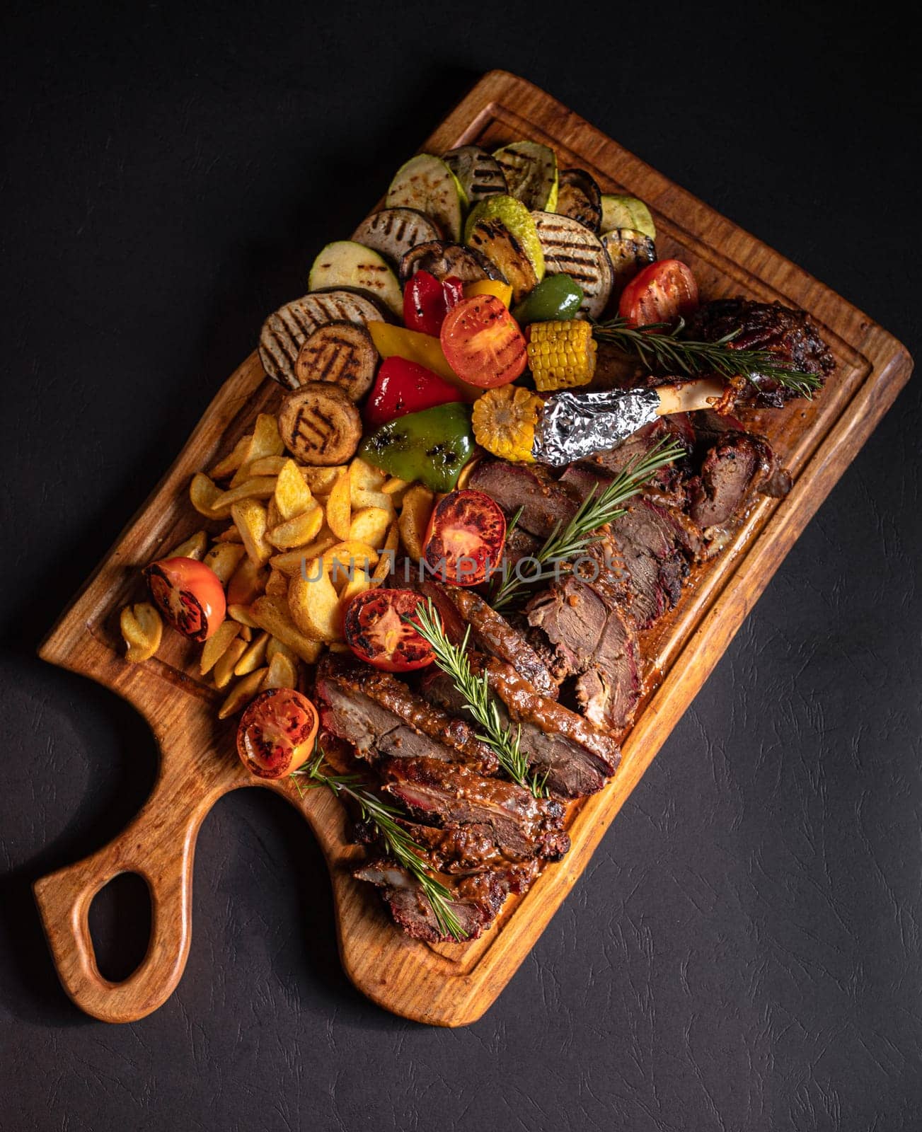 fried pieces of steak with vegetables on the grill on a wooden tray by tewolf