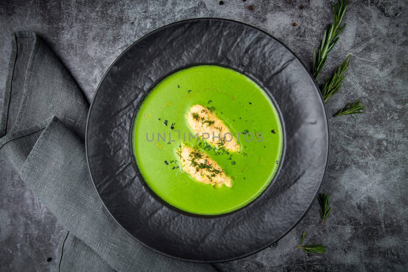 broccoli cream soup with pieces of chicken fillet on a dark background top view by tewolf