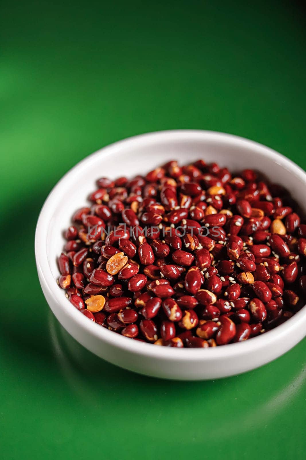 red roasted peanuts in a white bowl. Garnish. View from above. Chinese cuisine, hotpot ingredient