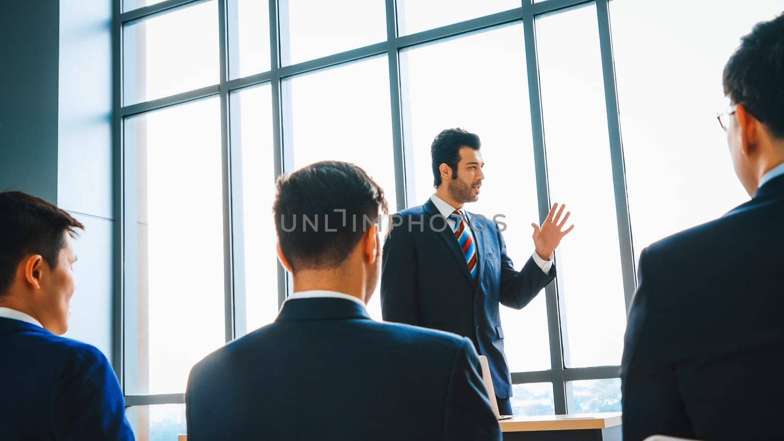 Group of business people meeting in a seminar conference . Audience listening to instructor in employee education training session . Office worker community summit forum with expert speaker . Jivy