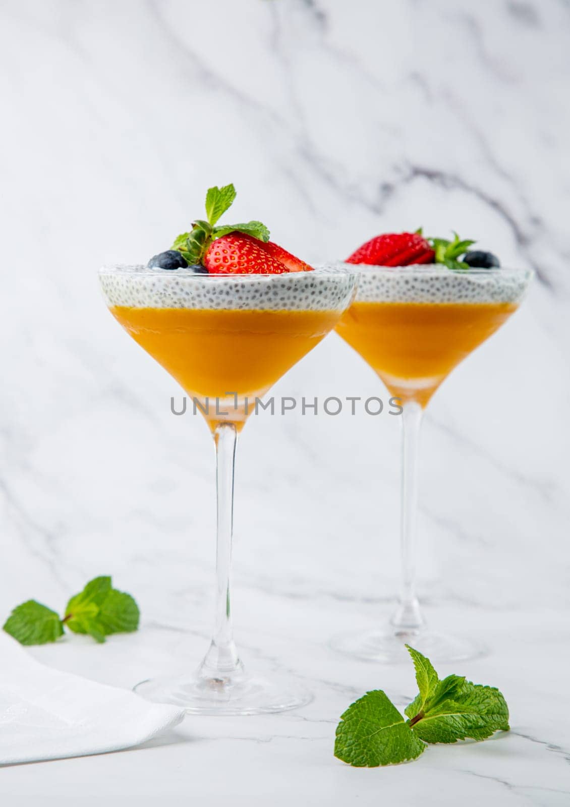 exotic fruit cocktails with berries and chia seed topping and mint side view by tewolf