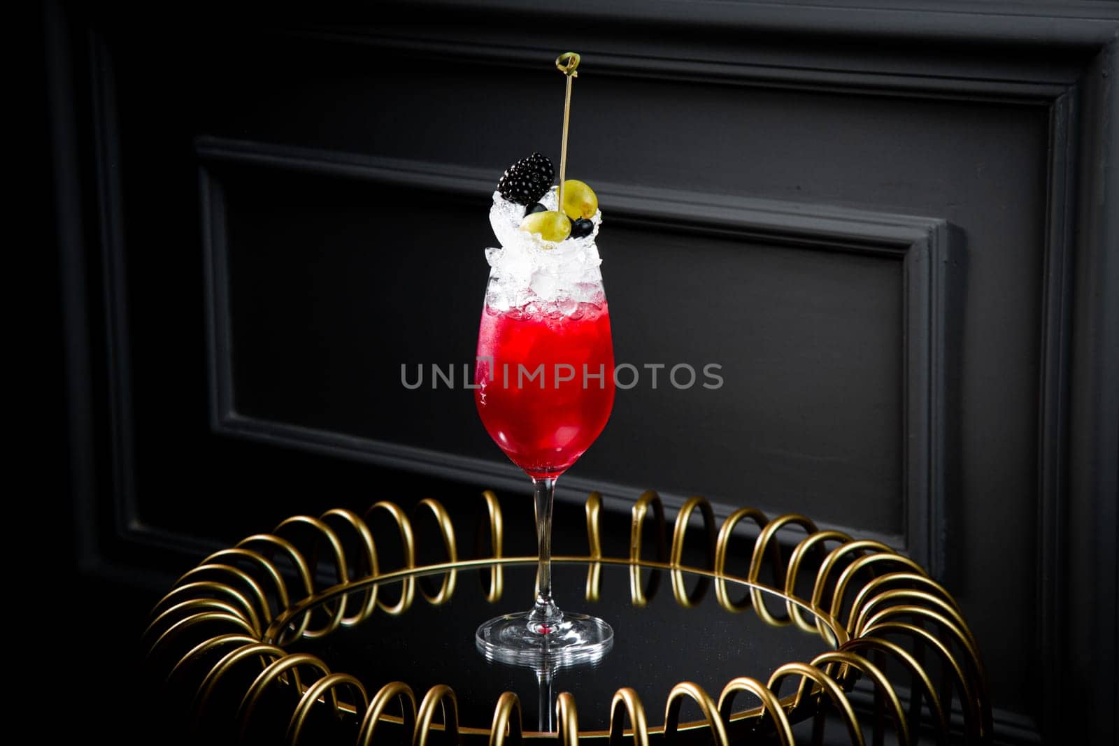 red cocktail on a dark background with whipped cream topping side view by tewolf