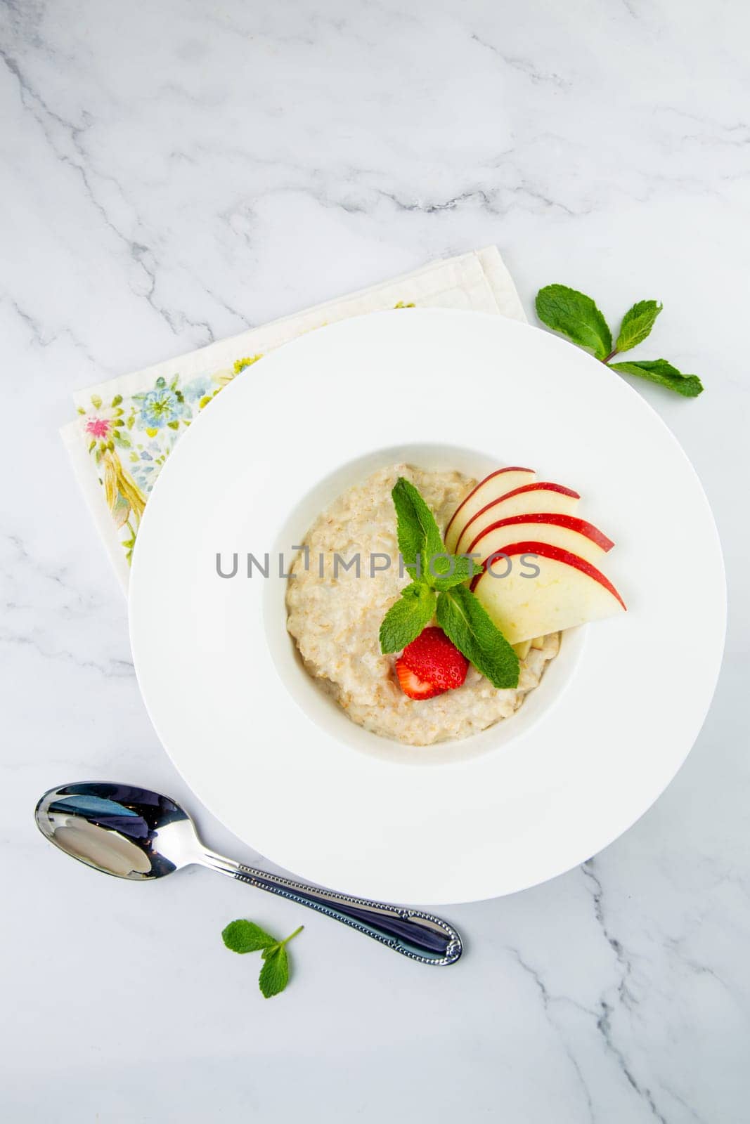 oatmeal with thinly sliced ​​apples, strawberries and mint