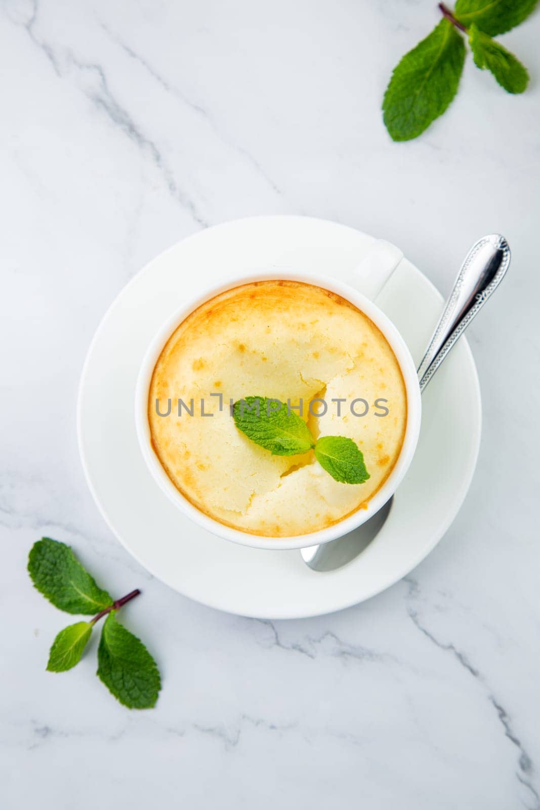 cup of coffee with foam and a sprig of mint on a marble background top view by tewolf