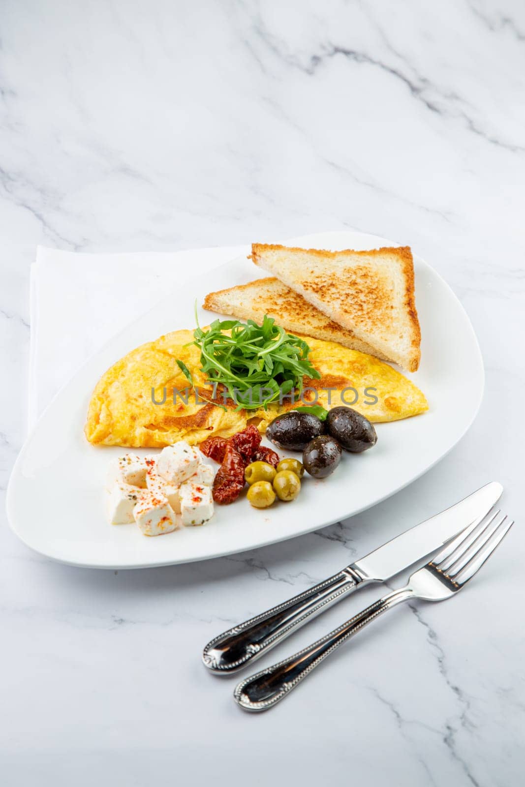 Breakfast of eggs with meat, herbs and drops of sauce with bread in a round plate side view by tewolf