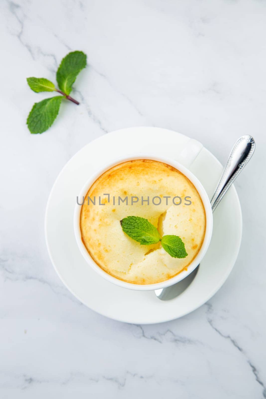 cup of coffee with foam and a sprig of mint on a marble background top view by tewolf