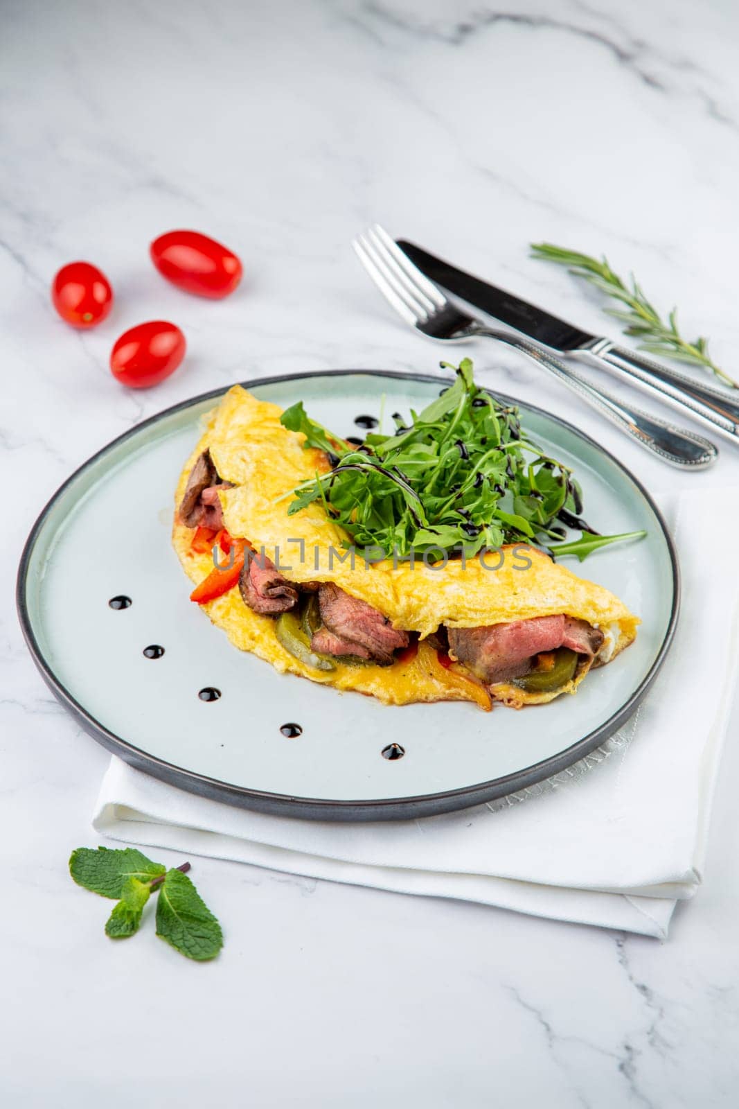 Breakfast of eggs with meat, herbs and drops of sauce in a round plate side view by tewolf