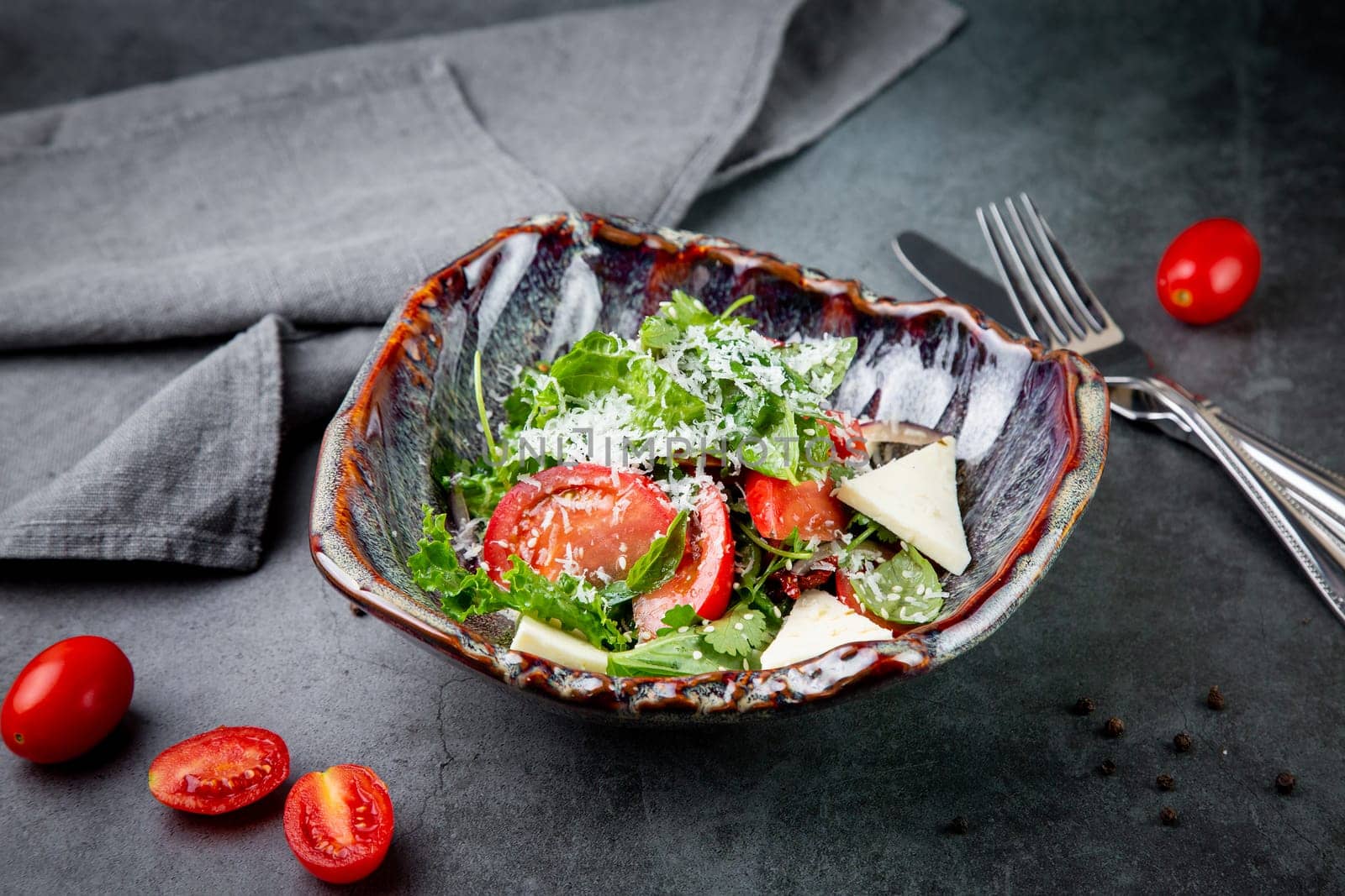 salad with tomatoes, feta cheese, lettuce and parsley in an unusual bowl side view by tewolf