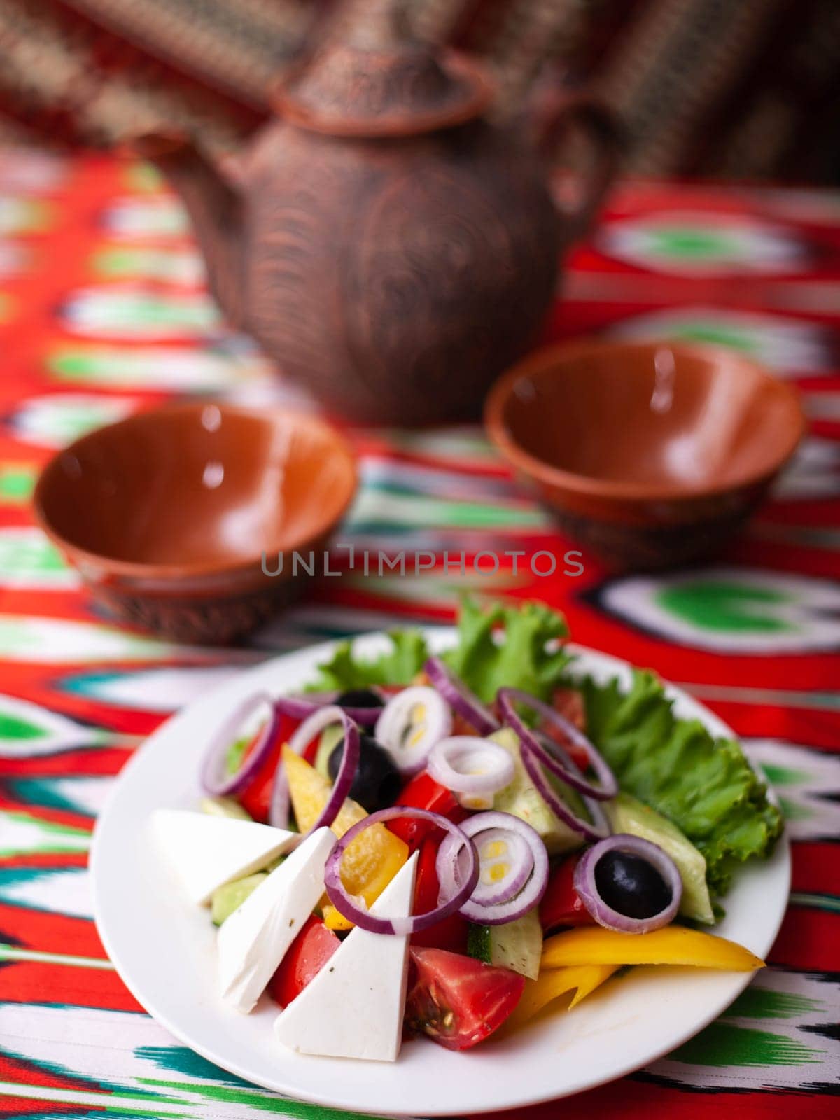 Vegetable slicing in Georgian style - tomatoes, cucumbers, greens, Bulgarian pepper, cheese, onion. Asian style. High quality photo